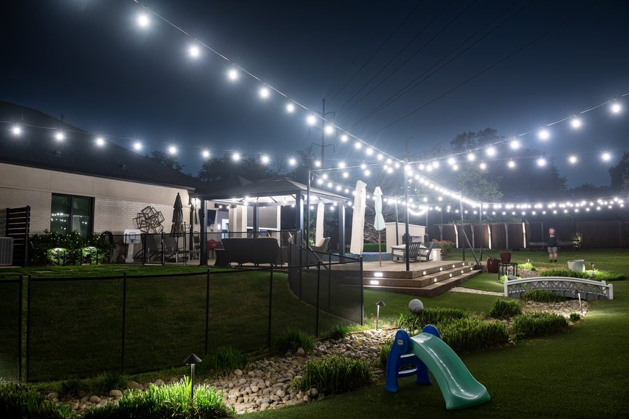 String lights spanning a large backyard at night