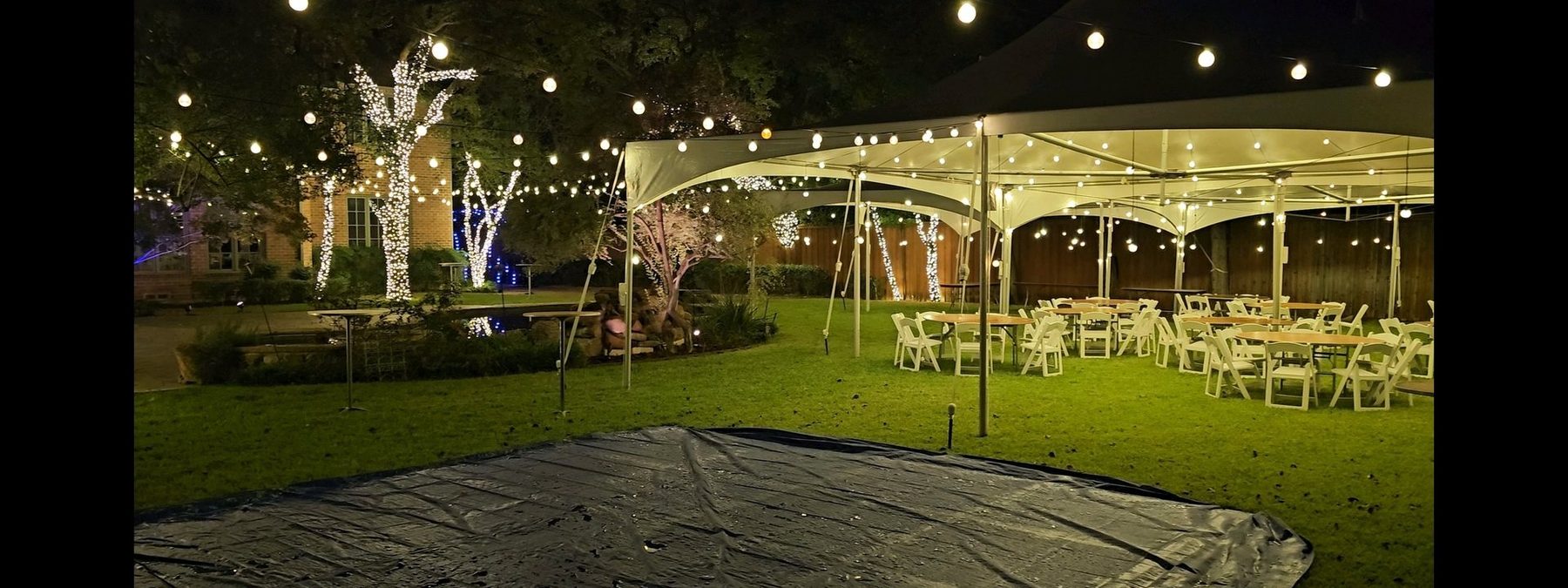 Outdoor event lighting — tent party with bistro strings and lit trees